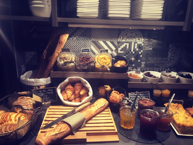 Breakfast spread of breads, croissants, and jams.