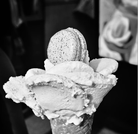 Gelato in a waffle cone topped with a Macaroon.